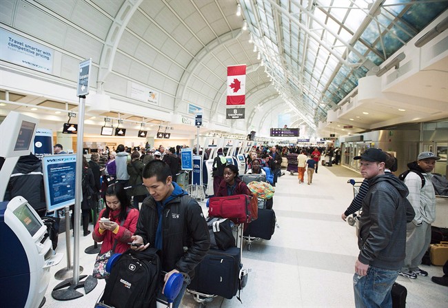 Passengers line-up during flight delays at Pearson International Airport in Toronto on Tuesday January 7, 2014. THE CANADIAN PRESS/Aaron Vincent Elkaim