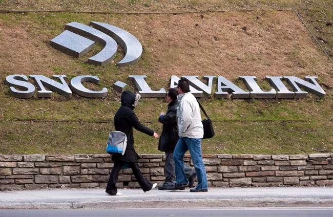 Pedestrians walk past the offices of SNC-Lavalin are seen March 26, 2012 in Montreal.
