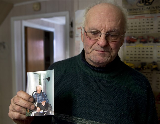 Jean-Andre Michaud holds a photo of his father, Paul-Etienne Michaud, 96, at his home Saturday, January 25, 2014 in L’Isle-Verte, Que. Michaud died in the fire at a seniors residence Thursday, Jan, 22, 2014. THE CANADIAN PRESS/Ryan Remiorz