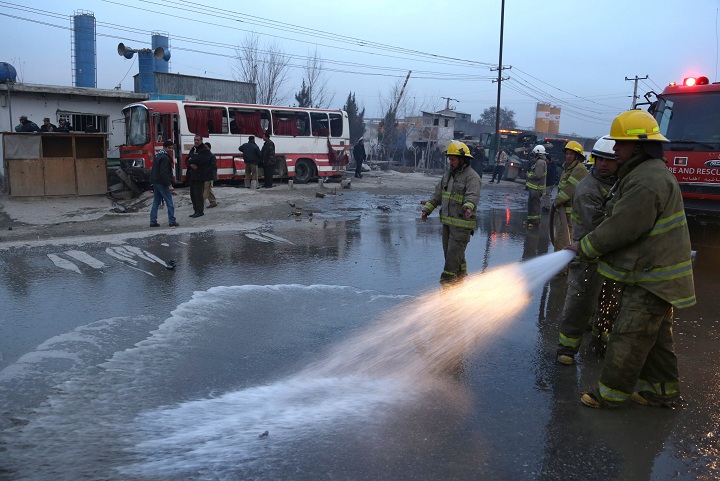 Afghan firefighters wash the street at the site of a suicide attack on a road in Kabul, Afghanistan, Sunday, Jan. 12, 2014. 