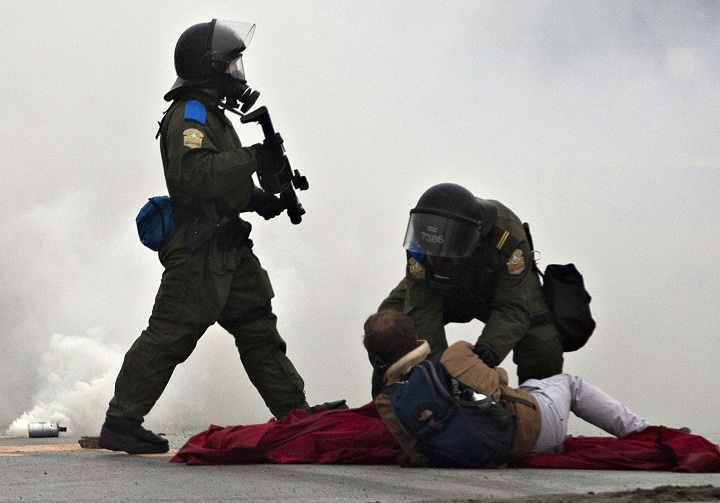 Provincial police officers confront protesters during a student demonstration outside the Quebec Liberal Party meeting Friday, May 4, 2012 Victoriaville, Quebec.