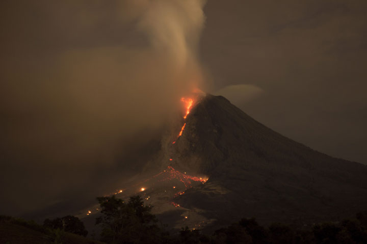 Mount Sinabung is pictured spewing smoke and lava is seen from Perteguhen village on Monday, January, 6, 2014 in Karo district, North Sumatra, Indonesia.