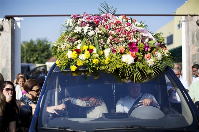 Relatives of Genesis Carmona, embrace inside the hearse carrying her body during her funeral, Friday, Feb. 21, 2014 in Valencia, Venezuela.