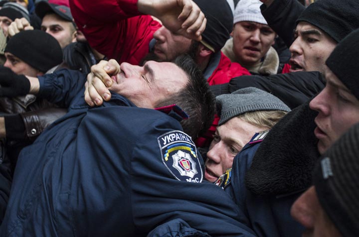 Crimean Tatars clash with a police officer , left, in front of a local government building in Simferopol, Crimea, Ukraine, Wednesday, Feb. 26, 2014. AP Photo/Andrew Lubimov