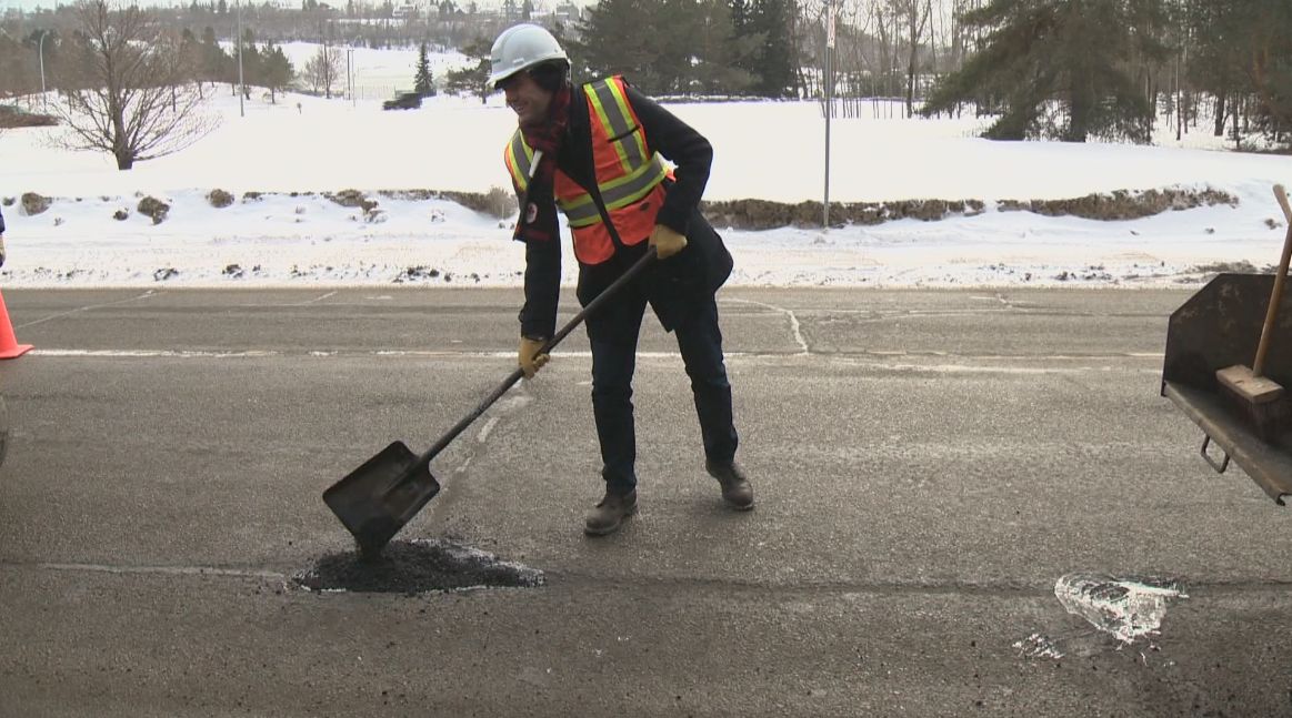 Mayor Don Iveson pitched in and helped fill a pothole Friday afternoon.