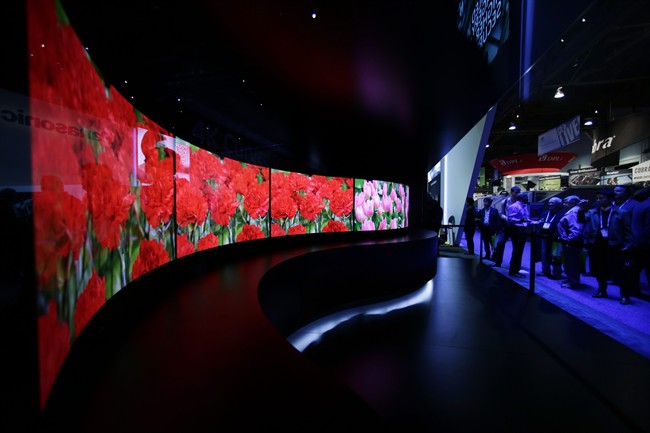 In this Jan. 7, 2014 file photo, attendees looks at the installation made with curved OLED displays at the Panasonic booth during the International Consumer Electronics Show in Las Vegas. Panasonic reports quarterly earnings on Tuesday, Feb. 4, 2014.