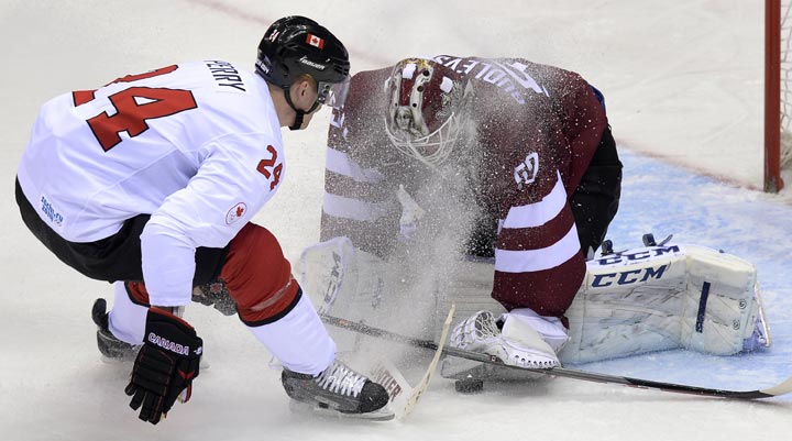 Canada’s Corey Perry attacks Latvia’s goalkeeper Kristers Gudlevskis during the Men’s Ice Hockey Quarterfinals Canada vs Latvia at the Bolshoy Ice Dome during the Sochi Winter Olympics on February 19, 2014. (Alexander Nemenov/AFP/Getty Images)