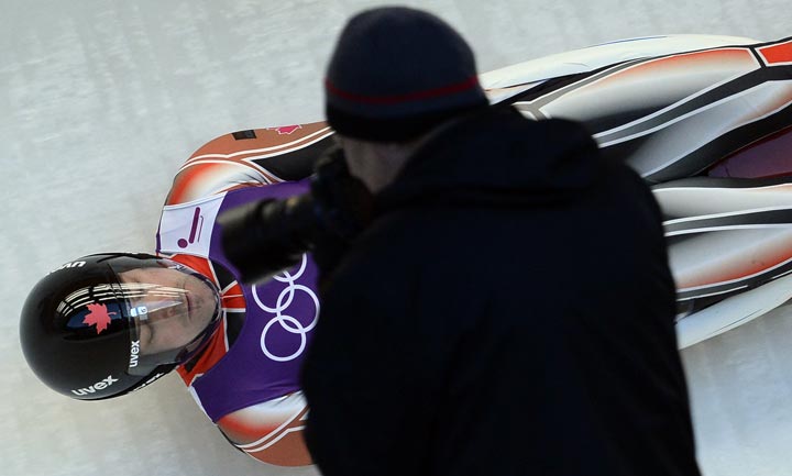 A photographer shoots an image of Canada’s Sam Edney during a practices run at the men’s Luge training session at the Sanki Sliding Centre in Rosa Khutor on February 6, 2014. (Lionel Bonaventure/AFP/Getty Images)