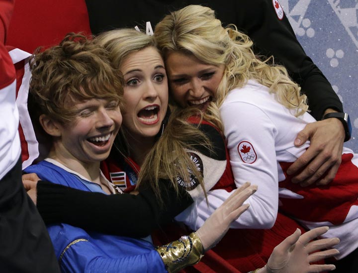 Kevin Reynolds of Canada, left, and team members react as he sits in the results area after competing in the men’s team free skate figure skating competition at the Iceberg Skating Palace during the 2014 Winter Olympics, Sunday, Feb. 9, 2014, in Sochi, Russia. (AP Photo/David J. Phillip )