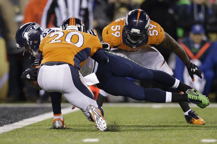 Seattle Seahawks’ Doug Baldwin dives between Denver Broncos’ Mike Adams, left, and Danny Trevathan for a touchdown during the second half of the NFL Super Bowl XLVIII football game Sunday, Feb. 2, 2014, in East Rutherford, N.J. (AP Photo/Julio Cortez)