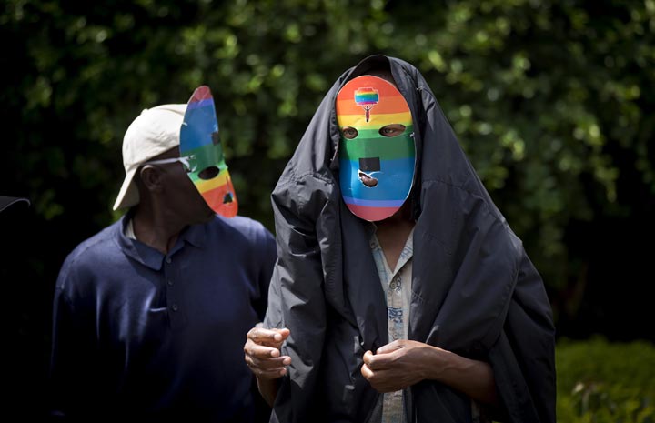 Kenyan gays and lesbians and others supporting their cause wear masks to preserve their anonymity as they stage a rare protest against Uganda's increasingly tough stance against homosexuality and in solidarity with their counterparts there, outside the Uganda High Commission in Nairobi, Kenya Monday, Feb. 10, 2014.