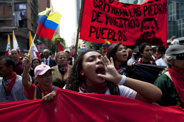 Members of a pro-government "colectivo," or "collective," march in downtown Caracas, Venezuela, Thursday, Feb. 20, 2014. President Nicolas Maduro and his supporters say the escalating protests against his socialist government in the oil-rich but economically struggling country are part of an attempted coup sponsored by right-wing and "fascist" opponents in Venezuela and abroad, particularly the United States. 