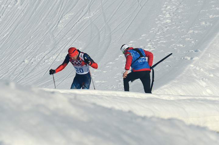 Russia’s Anton Gafarov is helped by Canada’s cross-country coach Justin Wadsworth after crashing in the men’s cross-country skiing sprint free semifinals during the Sochi Winter Olympics on February 11, 2014 in Rosa Khutor near Sochi. Wadsworth was applauded for showing the true spirit of the Olympics when he helped Gafarov to finish after breaking a ski in a crash.