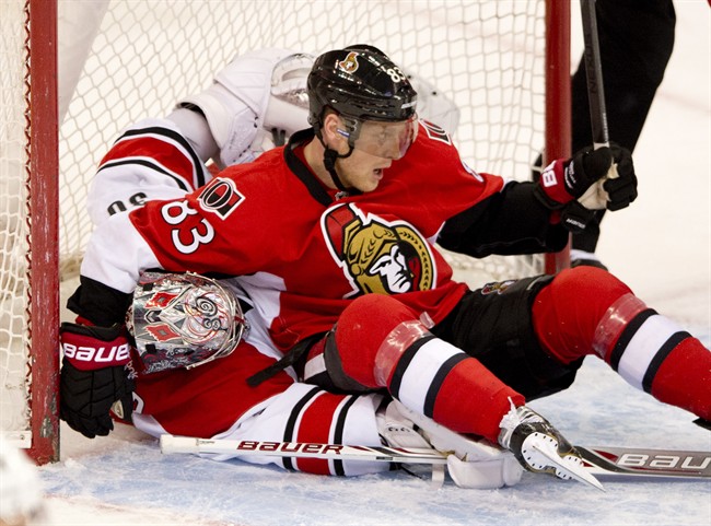 Ottawa Senators Ales Hemsky lies on top of Carolina Hurricanes goalie Cam Ward during first period NHL action Monday March 31, 2014 in Ottawa.