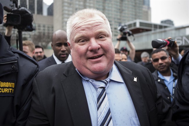 Toronto Mayor Rob Ford is pursued by the media outside city hall