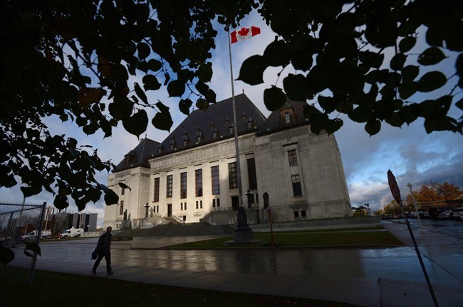 A pedestrian walks past the Supreme Court of Canada in Ottawa, Oct. 18, 2013. 