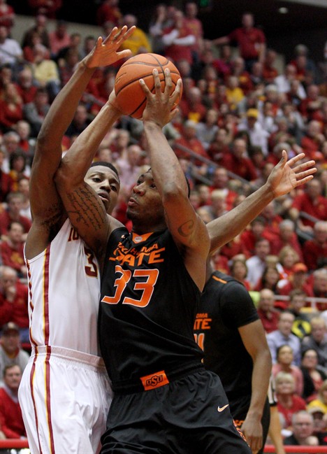 Oklahoma State guard Marcus Smart draws a foul on Iowa State forward Melvin Ejim as he drives to the basket during the second half of an NCAA college basketball game in Ames, Iowa, Saturday, March 8, 2014.