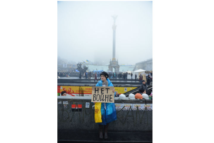 A protester in Kyiv's Independence Square holds a sign that reads "No War."