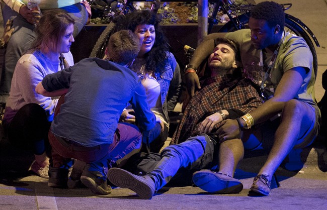 Unidentified people are comforted after being struck by a vehicle on Red River Street in downtown Austin, Texas, during SXSW on Wednesday March 12, 2014. Police say two people were confirmed dead at the scene after a car drove through temporary barricades set up for the South By Southwest festival and struck a crowd of pedestrians.