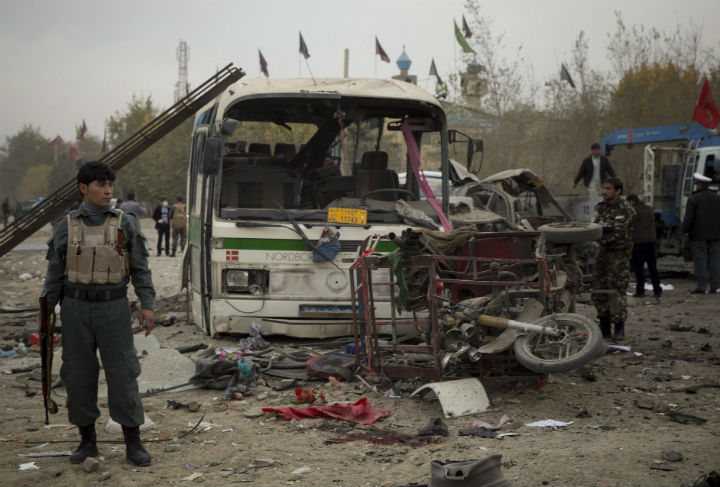 An Afghan policeman secures an area after a suicide vehicle bomb tore through the area on the outskirts of Kabul, Saturday, Nov. 16, 2013.