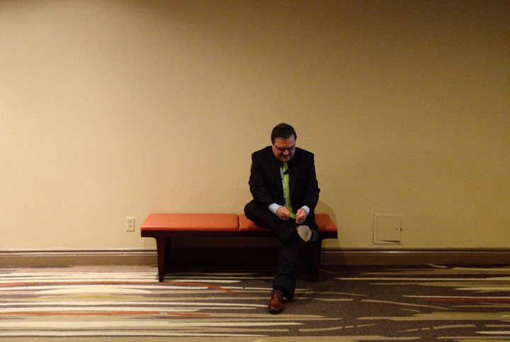 Minister of Finance Jim Flaherty ties his shoe before speaking at a post-budget event in Ottawa on February 12, 2014.