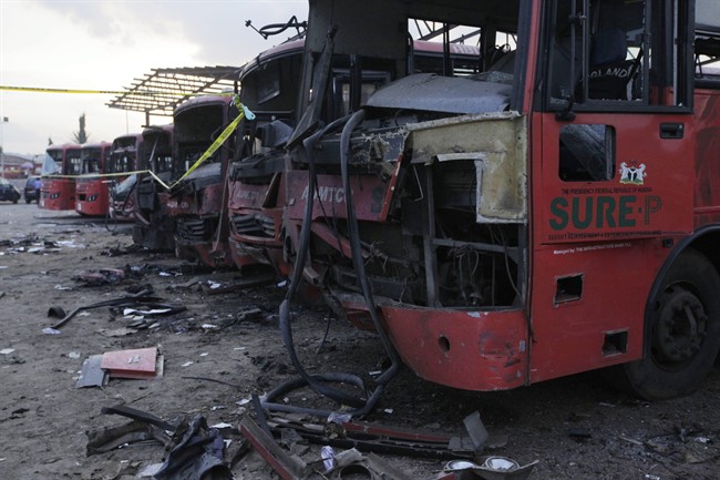 Damaged buses are seen at the scene of an explosion at a bus park in Abuja, Nigeria, Monday, April. 14, 2014.