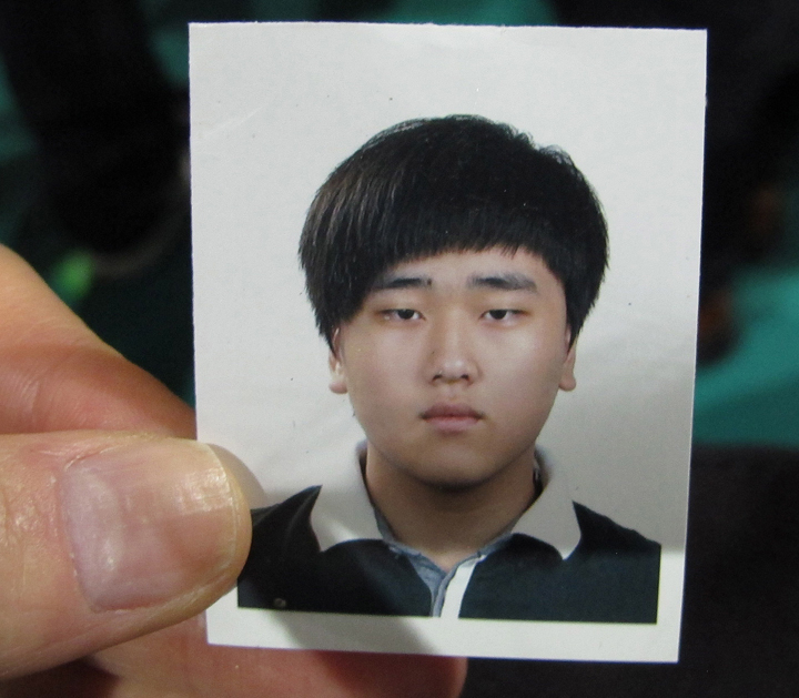 FILE – In this Saturday, April 19, 2014 file photo, a portrait of Lee Seok-joon, one of missing passengers aboard the sunken ferry Sewol, is shown by his father Lee Byung-soo during an interview at a gymnasium in Jindo, South Korea.