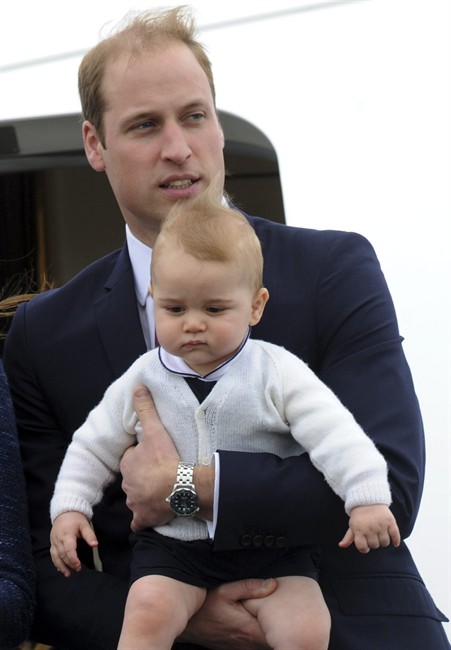Britain ‘s Prince William carries his son Prince George as they depart for Sydney, Australia, from Wellington, New Zealand, Wednesday, April 16, 2014.