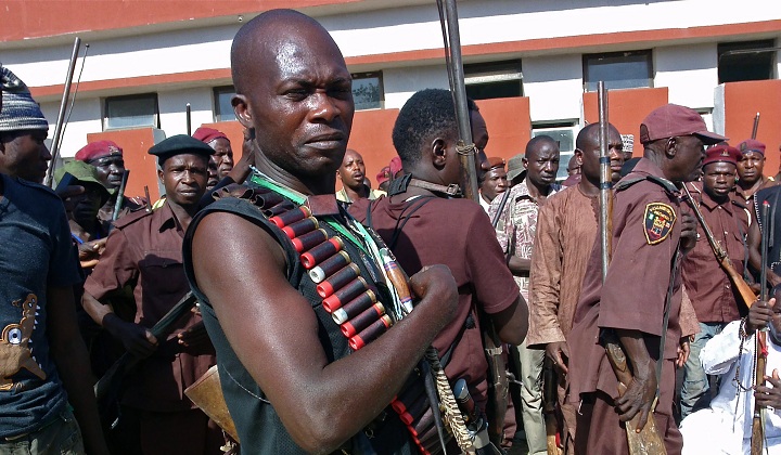 In this photo taken on, Sunday, May 18, 2014, armed hunters gather before looking for around 300 abducted school girls in Maiduguri, Nigeria. 