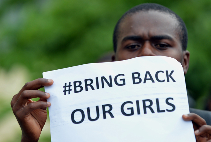 A participant at the World Conference on Youth 2014, hosted by Sri Lanka, poses for a photograph while holding a placard during a protest to demand the return of hundreds of school girls abducted by the Boko Haram separatist group in Colombo on May 9, 2014.