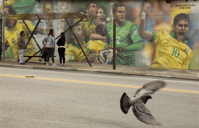 A mural of Brazilian soccer player Neymar, right, and others cover a wall by a bus stop in Sao Paulo, Brazil, Monday, May 26, 2014. The mural was painted by Brazilian street artist Rodolfo Turini ahead of the World Cup soccer tournament that starts in June. (AP Photo/Andre Penner)