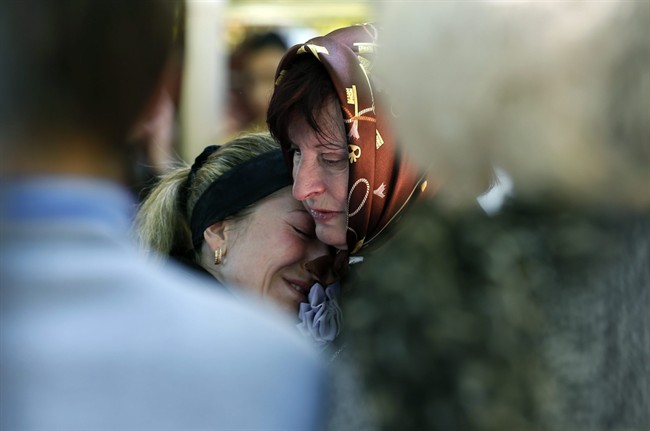Relatives mourn in front of the casket of a person killed during clashes between Ukrainian and pro-Russian forces last week, during a commemoration service in the center of Slovyansk, eastern Ukraine, Wednesday, May 7, 2014. 