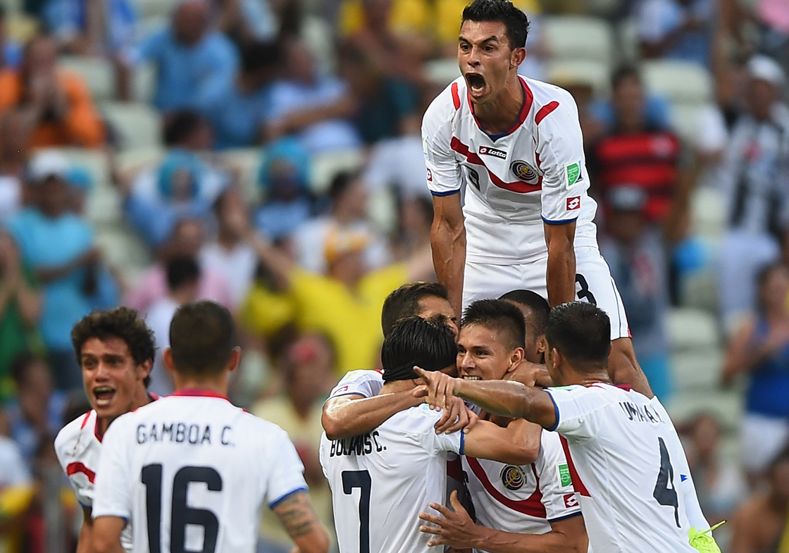 FORTALEZA, BRAZIL - JUNE 14: Giancarlo Gonzalez of Costa Rica jumps on his teammates as they celebrate the team's second goal by Oscar Duarte (C) during the 2014 FIFA World Cup Brazil Group D match between Uruguay and Costa Rica at Castelao on June 14, 2014 in Fortaleza, Brazil. (Photo by Laurence Griffiths/Getty Images)