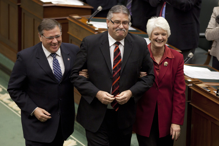 Newly elected Speaker of the Ontario Legislature, Liberal MPP Dave Levac (C) is guided towards the Speaker's chair by fellow MPP's Jerry Ouellette and Liz Sandals at Queen's Park Nov. 21 2011.