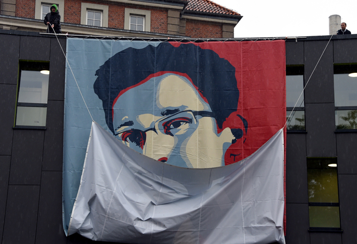 Students of the Muthesius Academy of Fine Arts and Design in Kiel uncoil a placard showing US intelligence leaker Edward Snowden as part of a campaign by German activists to grant asylum for Edward Snowden.