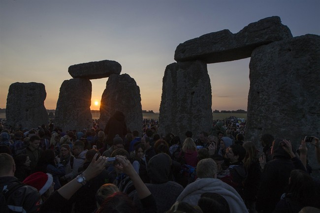 The sun rises as thousands gathered at the ancient stone circle Stonehenge, near Salisbury, England, to celebrate the summer solstice, the longest day of the year, Saturday, June 21, 2014.