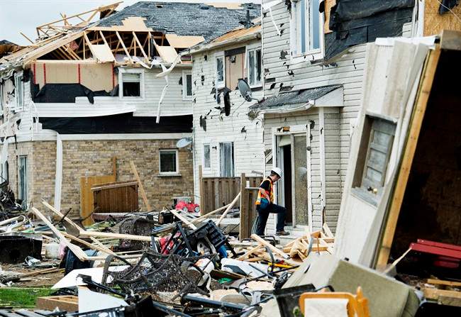 Investigators assess the damage to homes and property on Wednesday, June 18, 2014, a day after a tornado touched down in Angus, Ont . 