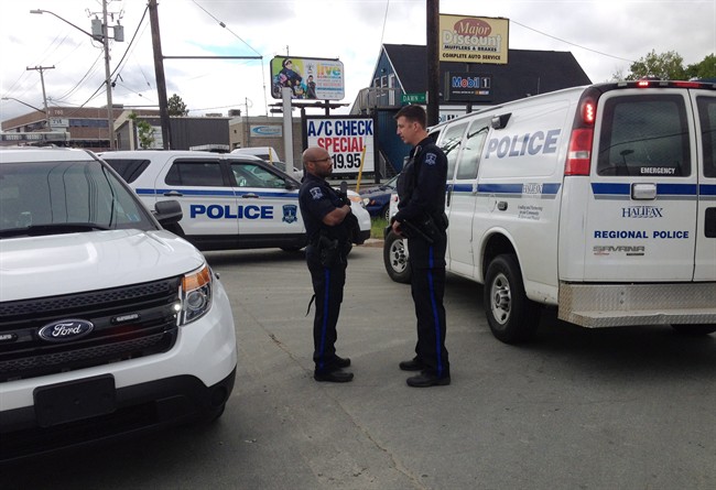Police officers talk during an investigation into a report of a gunman in Halifax on Saturday, June 7, 2014. THE CANADIAN PRESS/Darren Pittman