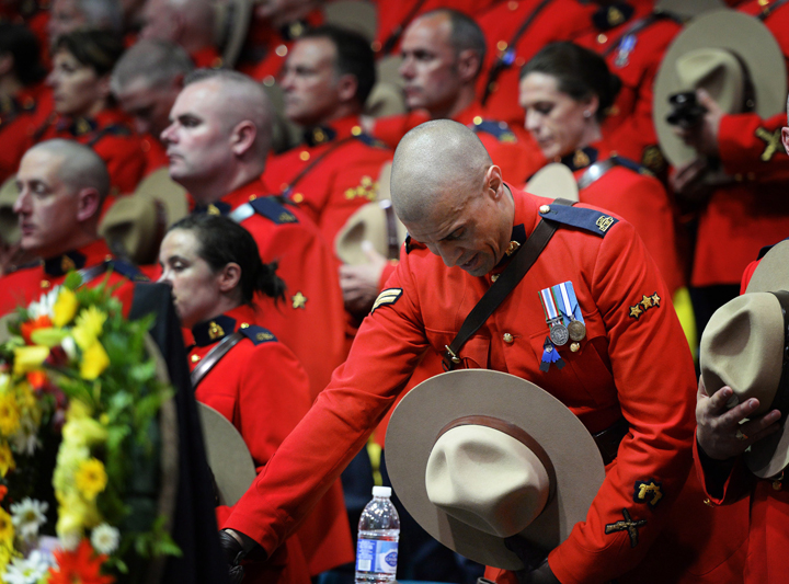 RCMP officers react as they attend the regimental funeral of three slain officers at the Moncton Coliseum in Moncton, N.B. on Tuesday, June 10, 2014. Const. David Ross, Const. Fabrice Georges Gevaudan and Const. Douglas James Larche were killed in a shooting spree last Wednesday.