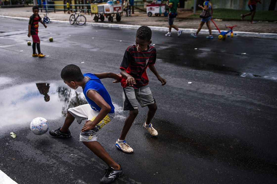 Brazilian children play football on a street near the Fonte Nova Arena stadium in Salvador on June 8, 2014, ahead of the 2014 FIFA World Cup in Brazil. AFP PHOTO / DIMITAR DILKOFF (Photo credit should read DIMITAR DILKOFF/AFP/Getty Images)