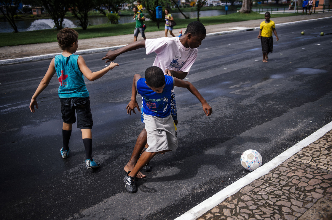 Brazilian children play football on a street near the Fonte Nova Arena stadium in Salvador on June 8, 2014, ahead of the 2014 FIFA World Cup in Brazil. AFP PHOTO / DIMITAR DILKOFF (Photo credit should read DIMITAR DILKOFF/AFP/Getty Images)