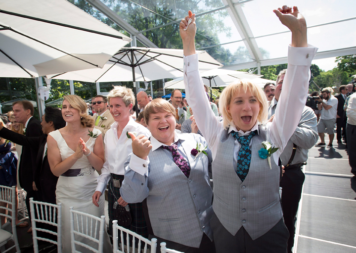Newly weds celebrate after over 100 gay couples participated in a mass wedding during World Pride 2014 at Casa Loma in Toronto, on Thursday, June 26, 2014.