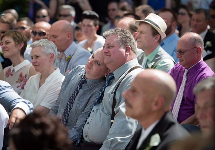 Steven B. Andrews rests on his husband Michael Dow’s shoulder while joining over 100 other gay couples in a mass wedding during World Pride 2014 at Casa Loma in Toronto, on Thursday, June 26, 2014.