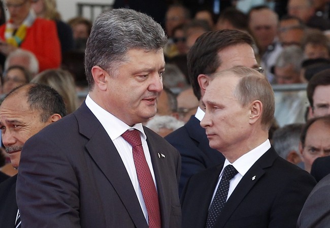 Ukraine's President-elect Petro Poroshenko, left, walks past Russian President Vladimir Putin during the commemoration of the 70th anniversary of the D-Day in Ouistreham, western France, Friday, June 6, 2014. (AP Photo/Christophe Ena, Pool).