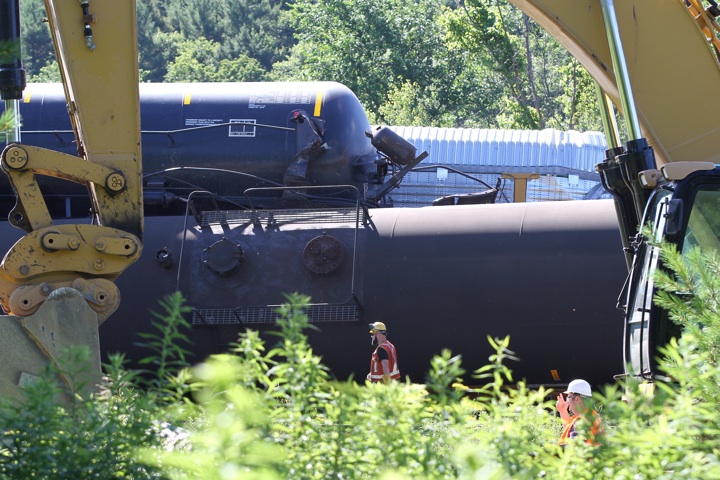 Workers try to remove the derailed CN train cars near Brockville, Ont., on Thursday July 10, 2014.