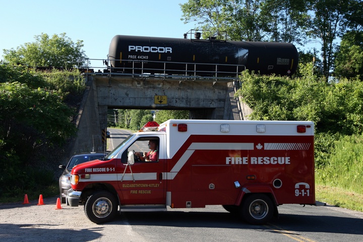 Firefighters and police stands near train tracks near Brockville, Ont., on Thursday July 10, 2014.