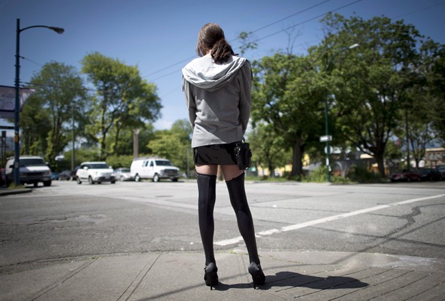 A sex trade worker is pictured in downtown Vancouver, B.C., Wednesday, June, 3, 2014. A Toronto newspaper says it will defy the ban on sex ads that goes into effect on Dec. 6, 2014.