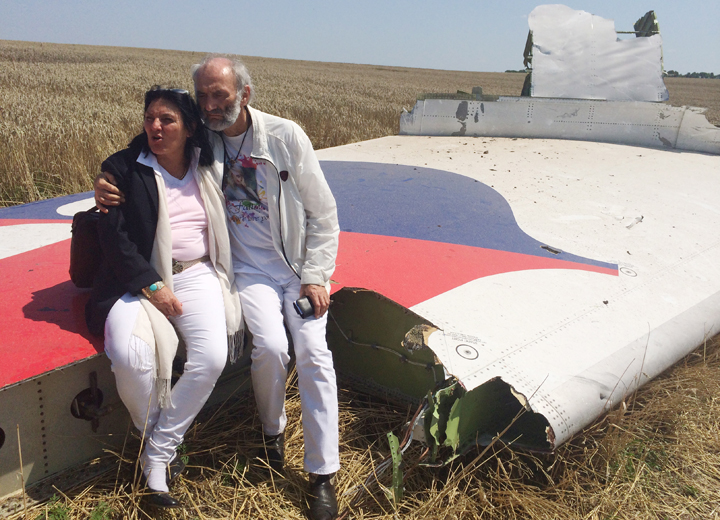 Jerzy Dyczynski and Angela Rudhart-Dyczynski whose daughter, 25-year-old Fatima, was a passenger on Malaysia Airlines flight MH17, sit on part of the wreckage of the crashed aircraft in Hrabove, Ukraine, Saturday, July 26, 2014.