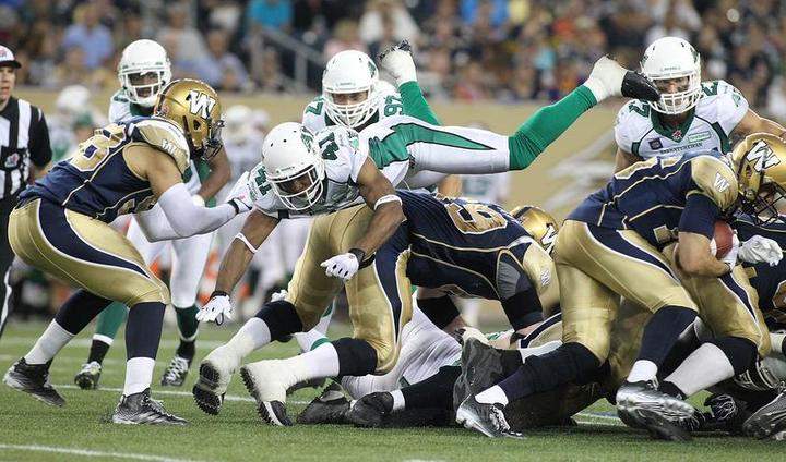 Tyron Brackenridge #41 of the Saskatchewan Roughriders goes airborne in an effort to stop make the stop against Robert Marve #16 of the Winnipeg Blue Bombers on Thursday in Winnipeg.