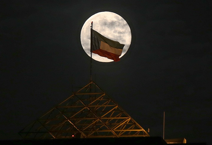 The "supermoon" is seen rising above the Kuwait skyline on August 10, 2014.